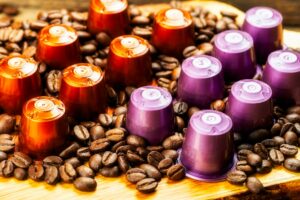 Espresso coffee capsules or pods and coffee beans on wooden rustic background